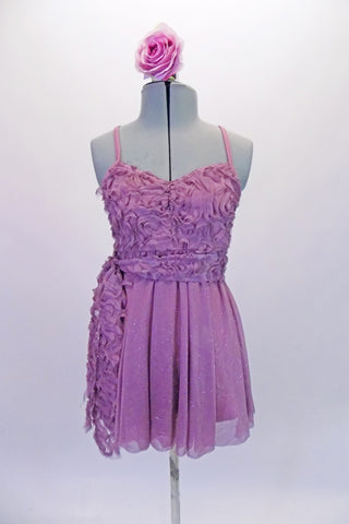 Pretty pale mauve purple, camisole dress has ribbon rose bodice and sash with cross back. The flowing skirt has a lovely subtle shimmer and cascades in the back. Comes with a rose hair accessory. Front