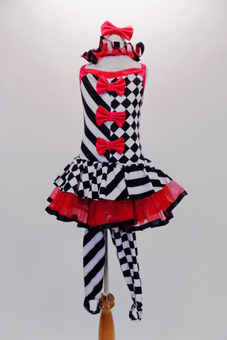 Harlequin themed tutu dress is an alternating pattern of black-white stripes & black-white checks. A red tulle skirt with black satin ribbon makes the skirt & matches the ruffled collar. Three red bows accent the bodice. Comes with red hair bow & stirrup socks. Front