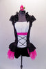 Peasant style costume has a white gathered bust accented with crystals above a white bodice with faux lace inlay. Pink & black lace on sides & back with cap sleeves &  Elizabethan ruffled neck. The peplum bustle over the black short is black lace & pink tricot. Comes with a floral hair accessory. Front