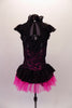 Peasant style costume has a white gathered bust accented with crystals above a white bodice with faux lace inlay. Pink & black lace on sides & back with cap sleeves &  Elizabethan ruffled neck. The peplum bustle over the black short is black lace & pink tricot. Comes with a floral hair accessory. Back