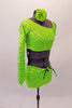 This two-piece neon lime green costume comes with an angled, single shoulder half top has a jewelled bow accent at the left bust below the shoulder strap. The back is comprised entirely of a series of crossing 1” straps. The bottom is sequined shorts with front knot tie accent. Comes with matching hair accessory. Right side