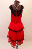 Saloon girl themed, knee-length dress has layers of red, lace-trimmed sheer skirt attached to a red velvet bodice. Black fringe adorns the shoulders and extends along the back Comes with crystalled rose hair accessory. Back