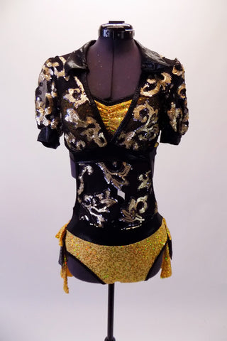 Black & gold leotard has a gold sequined floral leaf pattern along the front of the torso. Beneath is a gold sequined bra with black banding. The gold sequined brief has an attached bustle skirt with layers of sequined gold & black ruffles. The back is open revealing the bra & creates the appearance of a shrug. Front