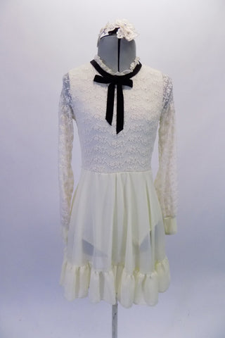 Delicate ivory dress has full lace upper with ruffled neck and black velvet tie accent. The knee-length chiffon skirt has a large ruffle edge. Comes with a beautiful lace hair accessory. Front