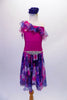 Lovely one-shouldered dress has a fuchsia leotard base with chiffon neck ruffle is shades of blue purple and fuchsia. The attached matching chiffon, knee-length skirt is light and flowy for a nice effect. The pop comes from a gorgeous crystal accessory at the waist. Comes with a large blue floral hair accessory. Front