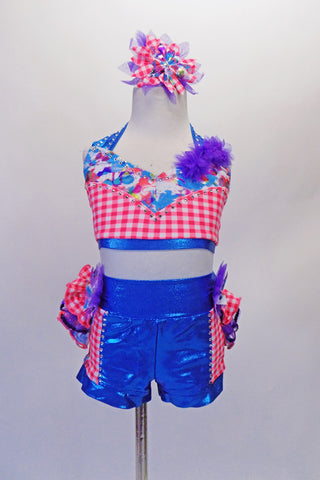 Two-piece costume comes with bright blue metallic shorts with coral check sides. The short has a 3-layered bustle of ruffles in bright colours. The halter top is coral check with floral accent, purple flower and crystal accents. Comes with a large matching hair accessory and matching gauntlets. Front