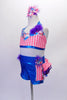 Two-piece costume comes with bright blue metallic shorts with coral check sides. The short has a 3-layered bustle of ruffles in bright colours. The halter top is coral check with floral accent, purple flower and crystal accents. Comes with a large matching hair accessory and matching gauntlets. Side