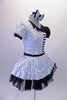 Piano themed dress is silver sequined on right side of bodice & skirt overlay. The left side, single lapel collar & petticoat are black. The costume has colour matched pouffe sleeves. A piano keyboard is appliqued on the left side of the torso. The back is looped with a silver bow. Comes with a bow hair accessory. Right side