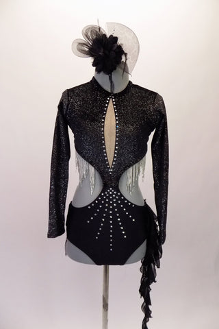 Leotard costume has a black glittery, long-sleeved upper. It is joined at the mid centre to the bottom & opens at the side & back with a thin strap. The front has nude inlay. Silver beaded fringe lines the front bodice. The brief is adorned with black fringe & chiffon hip accents. Comes with a black hair accessory. Front
