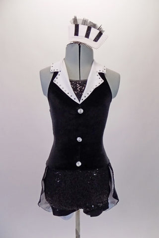 Short halter unitard has velvet bodice with large white, crystal-lined lapel, bandeau back and black sequined inlay. The black sequined bottom has an attached tail-coat style bustle. White jewelled buttons accent the front of the torso. Comes with matching hair accessory. Front