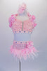 Pink 2-piece costume has a sequined, front gathered bra top. The halter collar & back straps have a 3-D satin-organza rose-ribbon trim. The 3 back straps are covered with large jewel accents. The brief has ostrich feather skirt, jewelled waistband &  floral accent at the hip. Comes with a pink hair accessory. Front