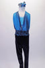 Full unitard has a blue metallic halter bra top beneath a shawled halter with black velvet bottom. The gathered shawls are attached at the centre of the waistband of the black velvet leggings and come up over the bust on either side clipping at the back of the neck. Comes with a blue floral hair accessory. Front