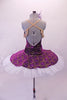 Tutu has a deep purple velvet base with gold brocade design. The bodice has a lined, nude V-front bust area with crystal accents & gold crochet lace edging that extends to form draping shoulder loops. The back has cross straps for support. The overlay skirt with attached basque sits over top of the white pull-on tutu. Back