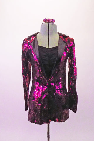 Fuchsia coloured full sequined blazer has a black star pattern and satin lapels. The blazer sits over the top of a simple black short unitard with gathered bust and camisole straps. Comes with matching hair barrette. Front