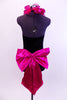 Black high neck halter leotard has collar of hot pink sequined roses. There is a large pink bow on behind. Has longs black gloves and matching hair accessory, Back 