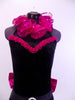 Black high neck halter leotard has collar of hot pink sequined roses. There is a large pink bow on behind. Has longs black gloves and matching hair accessory, Front Collar Zoom