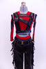 Red tank style leotard  is accompanied by, leather-like pants with fringes & studded belt.Leather strapped vest sits on top of red leotard. Matching hair piece. Front