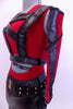 Red tank style leotard  is accompanied by, leather-like pants with fringes & studded belt.Leather strapped vest sits on top of red leotard. Matching hair piece. Side zoom