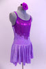 Pale lavender marble  leotard dress has purple glitter front bodice and low open back with cross straps.  A purple glitter swirled applique accent surrounds the glittery bodice. Comes with matching hair accessory. Right side