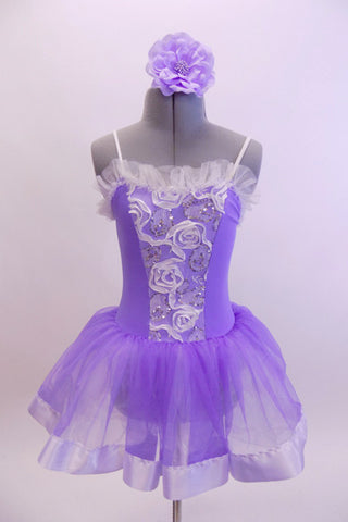 Pale lavender leotard dress has white ribbon rose detailed front bodice. The attached skirt is lavender organza that sits on layers of white tulle.  Comes with matching hair accessory. Front