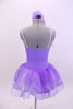 Pale lavender leotard dress has white ribbon rose detailed front bodice. The attached skirt is lavender organza that sits on layers of white tulle.  Comes with matching hair accessory. Done