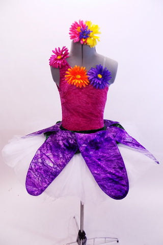 Magenta crushed velvet, one shoulder leotard, has colourful gerbera daisies along bodice & shoulder. Pull-on,white tutu has purple petal overlay with flowers. Matching hair accessory. Front