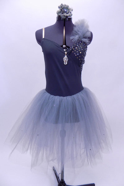 Grey cross over leotard dress has crystals on the left bust & long tulle skirt. There is a large drop crystal accent at the front. Comes with hair accessory. Front