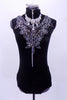High neck leotard has embroidered silver floral bib that snaps onto right shoulder Has full sheer back, large detachable crystal necklace & crystal barrette. Front