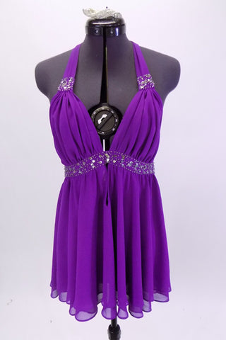 Purple chiffon baby doll top has triangle bust area with beaded lace under bust line and at base of ties. The ties are an extension of the bust area and tie behind neck. Comes with matching purple shorts and floral hair accessory. Front