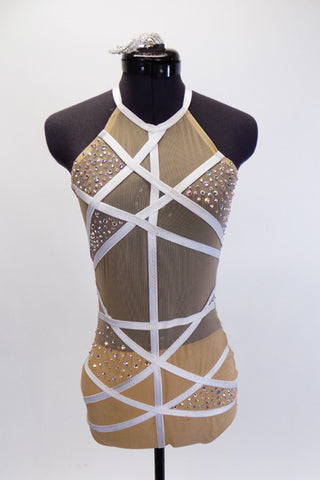 Nude mesh halter collar leotard has nude lining in bottom. White satin-elastic straps criss-cross in a random fashion across torso creating segments which are alternately filled with AB Swarovski crystals. Requires open back bras or stick cups. Comes with crystal barrette hair accessory. Front