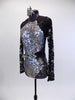 Long sleeved leotard has lace back and sleeves. The brief portion is silver with a black mesh overlay. The front of the leotard is covered in iridescent sequins and has a large jeweled belt which snaps at the back. Comes with a silver and black hair accessory. Side
