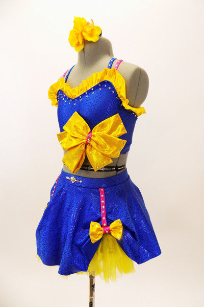Blue bra top with yellow ruffle & large bow accent. The matching skirt is a blue overlay with  of yellow  petticoat & bows accents. Has floral hair accessory. Side