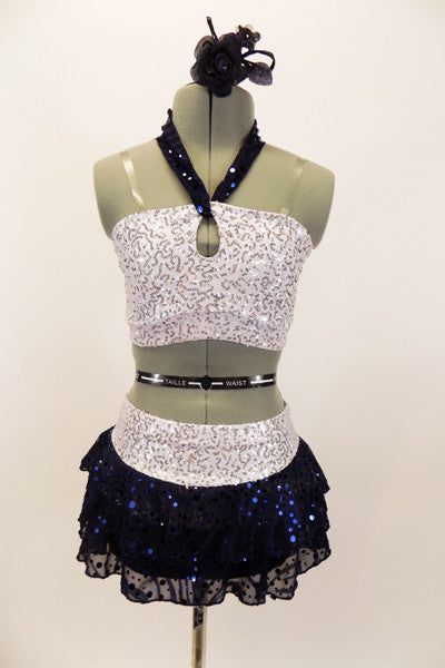 White & silver sequin bandeau bra top has front loop with navy halter collar. The briefs are separate from navy sequined lace skirt. Comes with hair accessory. Front