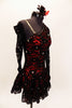 Red shimmery base one shoulder dress has  gathered skirt and black lace overlay with Swarovski accents throughout. The single sleeve and long gauntlet are both sheer black lace and accented with crystals. Comes with a matching red and black hair accessory. Right side