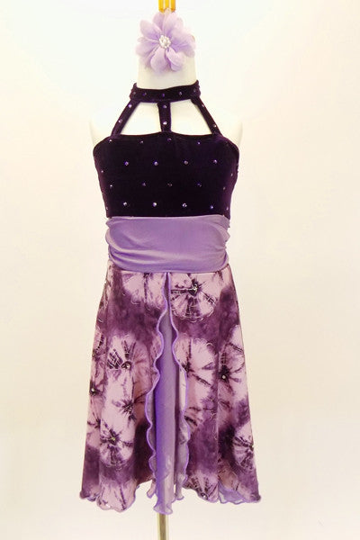 Purple dress has open front skirt with purple pansies over lavender base  Bodice is dark purple crystalled velvet with front straps. Comes with hair accessory. Front