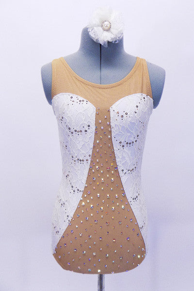 Nude mesh leotard has white sequined lace inserts on sides in a sweetheart shape. The center is covered with AB Swarovski crystals. Back is open with lace band up the center. Comes  with matching  white lace hair accessory. Front