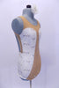 Nude mesh leotard has white sequined lace inserts on sides in a sweetheart shape. The center is covered with AB Swarovski crystals. Back is open with lace band up the center. Comes  with matching  white lace hair accessory. Right side