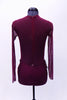 Maroon leotard has sheer long sleeves, back, sides and upper bust. The front bodice with deep “V” sweetheart neckline and bottom are a maroon lycra. A large applique extends from the left shoulder and covering left bust. Two additional appliques hug the hip curves on both sides below mesh.  The appliques are adorned with sequins, pearls and Swarovski crystals. Comes with crystal barrette. Back