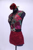 High collar leotard has nude front with black mesh adorned with large tropical sequin flowers of red, mauve and green. The open back is of sheer black mesh. The brief portion is a deep red lace and the costume is completed by a belt with large jeweled buckle accent and a floral hair accessory.  Left Side