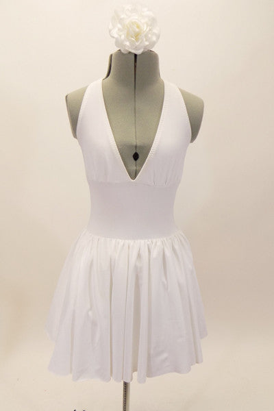 White, halter leotard dress has cross straps, low back & waistband separating the bust area & gathered skirt with tulle. Comes with floral hair accessory. Front