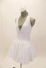 White, halter leotard dress has cross straps, low back & waistband separating the bust area & gathered skirt with tulle. Comes with floral hair accessory. Side