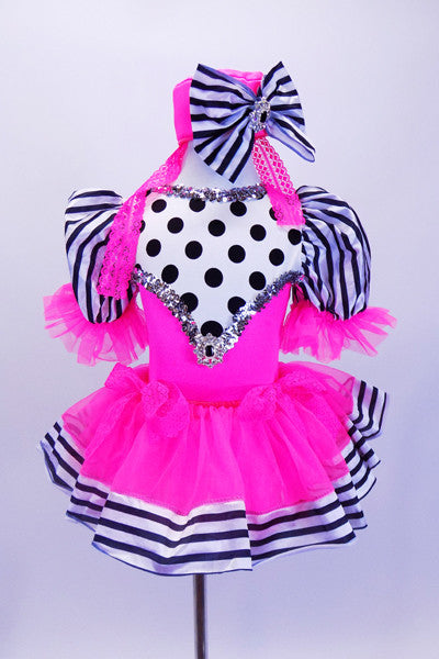 Pink costume has fluffy skirt over black and white polk-a-dot bodice,striped pouf sleeves & ribbon edging. The bodice and matching pill-hat have large crystal broach accents. Front