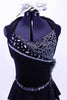 Black short unitard has peplum skirt & shawl collar. Bodice has mesh-chain design, silver cording & crystal accents. Has large beaded broach & hair accessory. Front zoomed