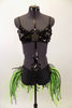 Costume has black large sequined bra top with broach. Black bottom has bustle skirt of multiple layers of green and black mesh tubes. Comes with hair accessory. Front