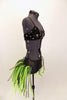 Costume has black large sequined bra top with broach. Black bottom has bustle skirt of multiple layers of green and black mesh tubes. Comes with hair accessory. Right side