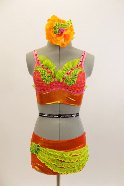 Two-piece costume has red and orange tartan bra with green lace ruffle trim, appliques & red crystals. Orange short has green lace ruffles & matching applique.Has matching hair accessory. Front