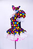 Black leotard dress has colorful puzzle piece decorative front with lace trim at neck sleeves and skirt. Dress has bright pink petticoat and matching bow hair accessory. Left side