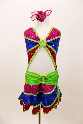 Pink, blue & red sequined dress has layered skirt, angled bust & open front torso. The bright green piping and waist is covered with hundreds of AB crystals. Has sequined hair accessory. Front