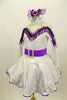 Silver dress has long sleeves and nude mesh upper. The bust-line is decorated with silver sequined, purple and white fringe. The dress has a wide purple belt with matching purple petticoat. Costume comes with silver and purple hair accessory. Left side