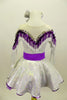 Silver dress has long sleeves and nude mesh upper. The bust-line is decorated with silver sequined, purple and white fringe. The dress has a wide purple belt with matching purple petticoat. Costume comes with silver and purple hair accessory. Back